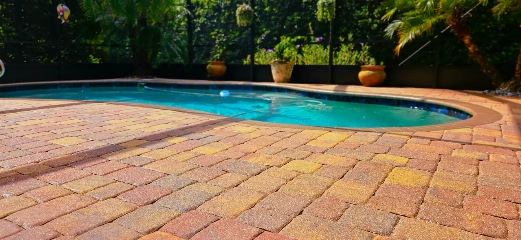 Freshly sealed brick paver pool deck